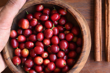 fresh coffee beans in wooden bowl with cinnamon on wooden background