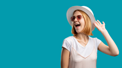 Holiday trip. Summer outfit. Happy woman in white and sunglasses touching gypsy hat isolated on blue copy space. Travel agency. Sun protection accessories