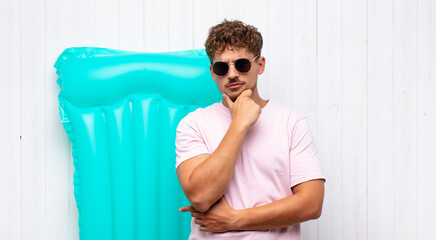 young man looking serious, confused, uncertain and thoughtful, doubting among options or choices....