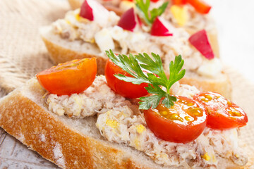 Closeup of crusty baguette with mackerel or tuna fish paste, healthy nutrition