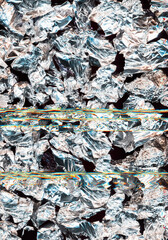 Silver abstract background. Glitched crystals effect. Chrome crushed foil with blue yellow reflection.