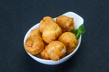 Sweet tasty profiteroles heap in the bowl