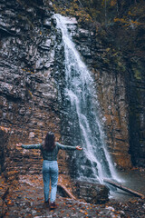 Obraz premium woman in casual clothes looking at waterfall
