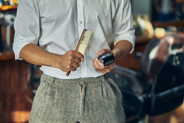 Schooled hair-stylist holding equipment for cleaning his tools