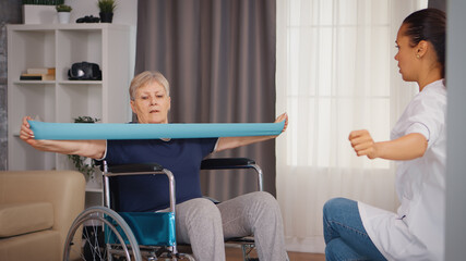 Senior woman in wheelchair doing rehabilitation treatment with assistance from nurse. Training, sport, recovery and lifting, old person retirement home, healthcare nursing, health support, social