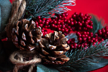 New year and Christmas background made of red and spruce twigs with cones, berries, ribbon and snow