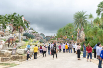 Blurred people walking to see dinosaurs in amusement park