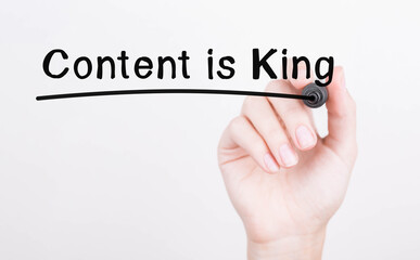 Hand writing Content is King with black marker on transparent wipe board