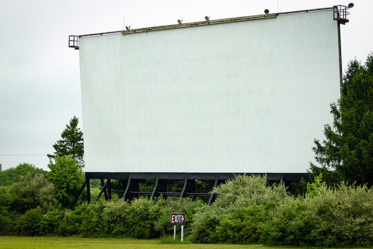 Blank white drive-in movie screen; rural outdoor setting