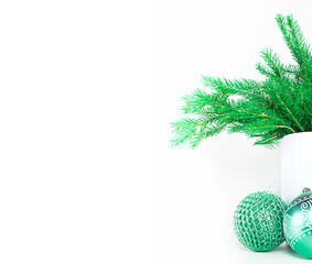 Christmas composition in white vase with christmas tree and balls on white background. Space for text