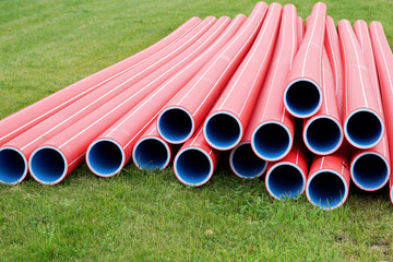   Polypropylene pipes lie on the grass ready for welding and laying the pipeline.