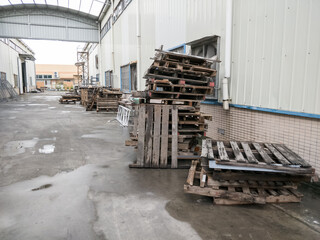 stacks of old wooden pallets outside a factory