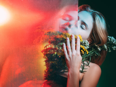 Natural cosmetology. Organic skincare. Double exposure sensual woman with closed eyes orange flowers in red bokeh light with old film dust scratches stains effect isolated on green. Beauty enhancement