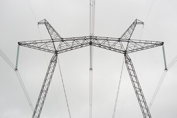 Power line support. High voltage transmission. Metal construction. Wires, insulation. Gray cloudy...
