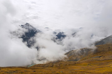 Alpine landscape. Photo of clouds from a high mountain. The birth of clouds in the mountains. Soft focus. Clouds float between the mountains.