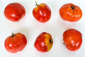 Six ripe yellow-red tomatoes on a white background. Healthy food concept
