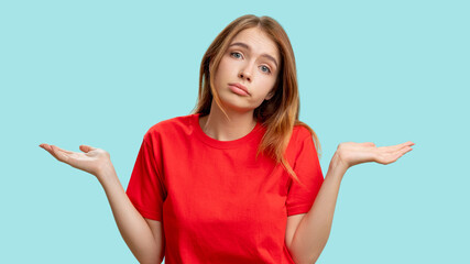 Clueless woman portrait. Whatever gesture. Indifferent lady in red t-shirt shrugging isolated on...