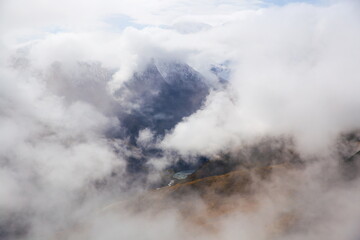 Alpine landscape. Photo of clouds from a high mountain. Soft focus. Clouds float between the mountains.