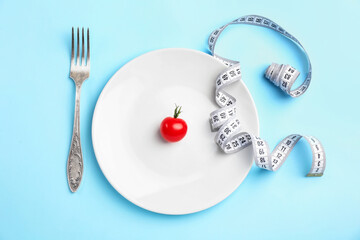 Plate with measuring tape, tomato and fork on color background. Concept of anorexia