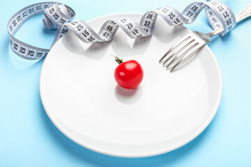 Plate with measuring tape, tomato and fork on color background. Concept of anorexia