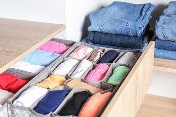 Open drawer with clean clothes in closet