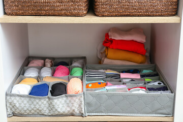 Organizers with clean clothes in closet