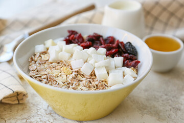 Bowl with tasty sweet oatmeal on table