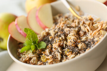 Bowl with tasty sweet oatmeal on table, closeup