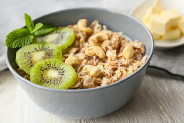 Bowl with tasty sweet oatmeal on table