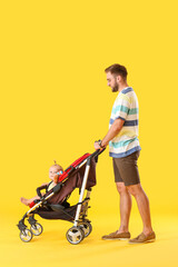 Father and his cute baby in stroller on color background