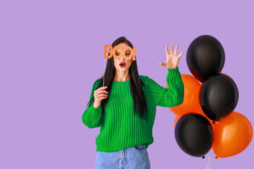 Beautiful young woman with balloons and Halloween decor on color background