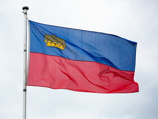 Flag of Liechtenstein waving on cloudy sky background