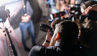 Professional photographers photograph a person. The concept of a photo session, press conference. Selective focus.