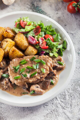 Pork loin chop with mushroom sauce and baked potatoes