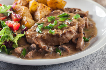 Pork loin chop with mushroom sauce and baked potatoes