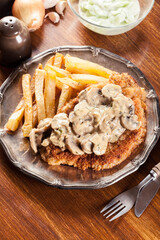 Traditional hunter schnitzel with a mushroom gravy and french fries