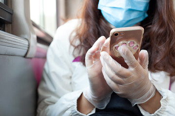 Closeup of holding mobile phone in hand wearing protective gloves