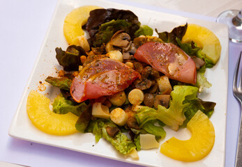 Exotic salad with pineapple, bacon, mushrooms and cheese at plate, dish of french cuisine