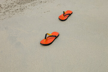 pair of slippers on a sandy ocean beach background
