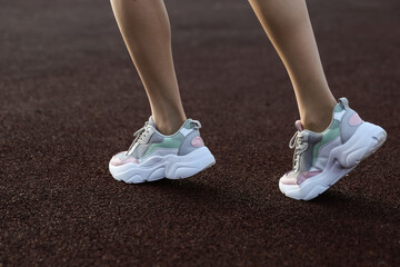 woman's legs wearing sporty sneakers outdoor close up