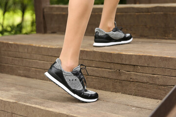 woman's legs wearing sporty sneakers outdoor close up