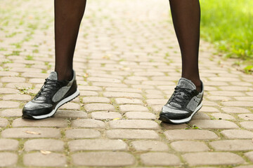 woman's legs wearing sporty sneakers outdoor close up