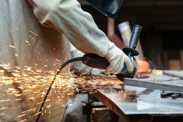 worker's hands sawing with a grinder close-up