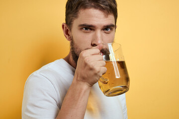 Man with a mug of beer fun alcohol lifestyle white t-shirt yellow isolated background