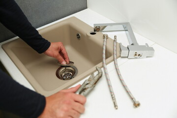 plumber installs kitchen faucet. refurbishment in the kitchen 