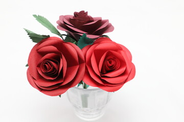 グラスに飾った折り紙で作った赤いバラの花
