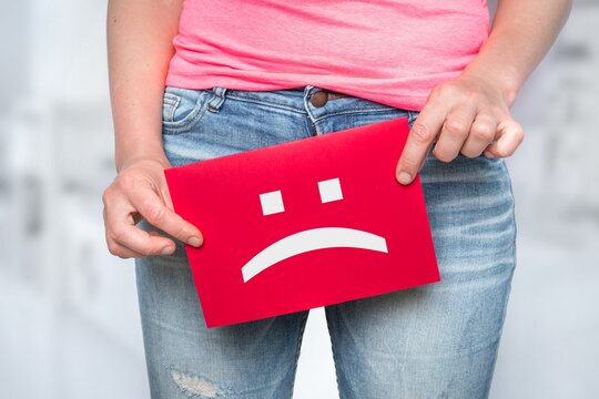 Woman With Incontinence Problem With Sad Smiley On Paper