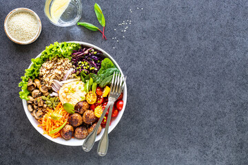 Grilled chicken, rice, spicy chickpeas, avocado, cabbage, pepper buddha bowl on dark background, top view. Delicious balanced food concept