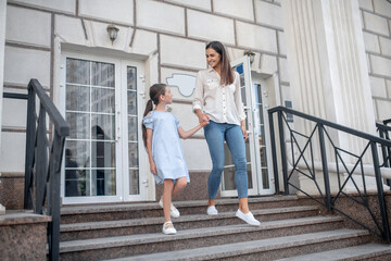 Mom and daughter going out the house and looking peaceful