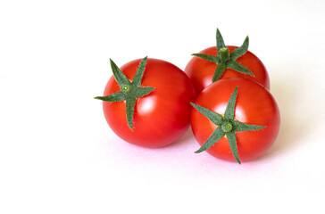 Three fresh ripe red tomatoes on a white background